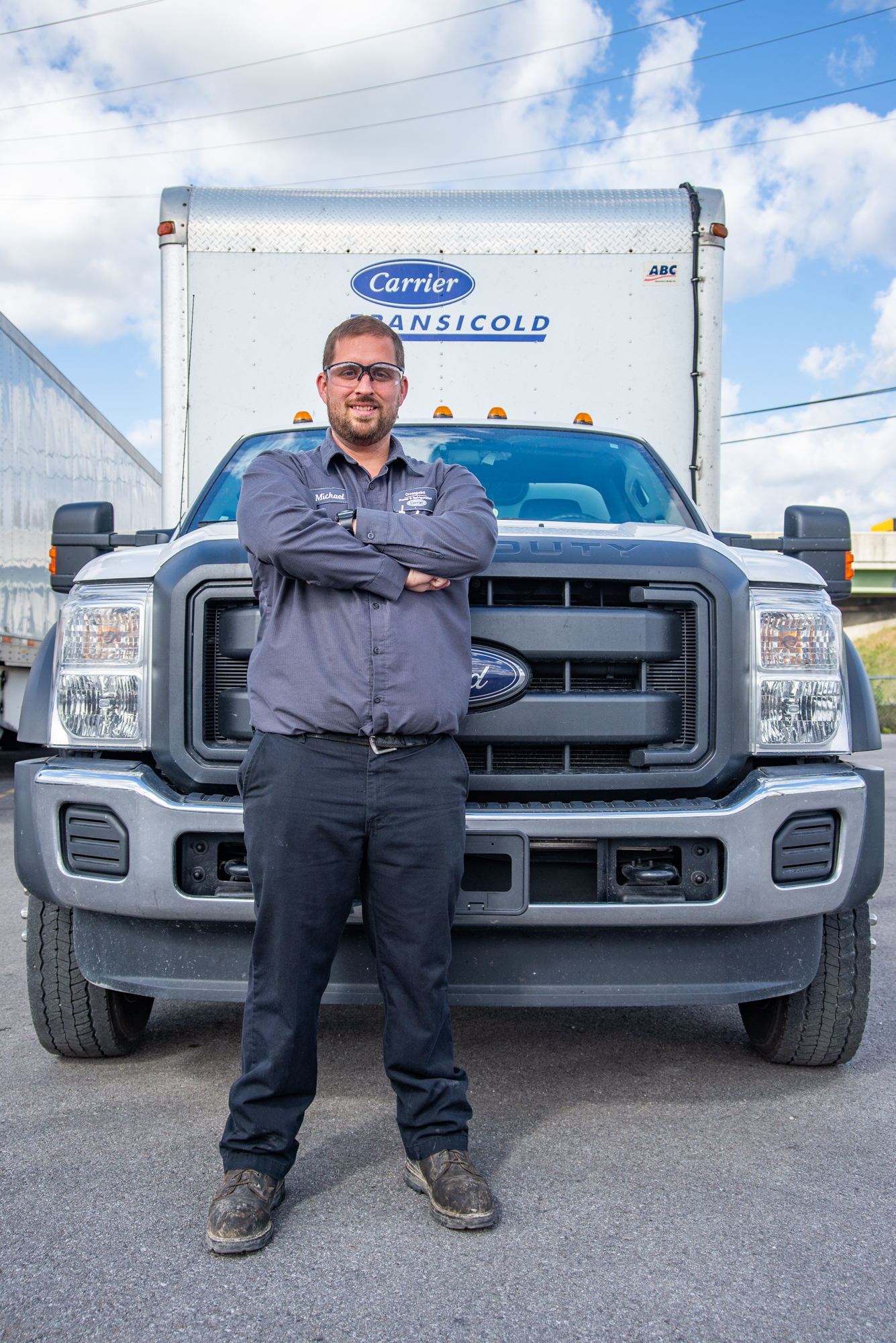 A Crosspoint Power and Refrigeration mobile service technician standing in front of a service truck