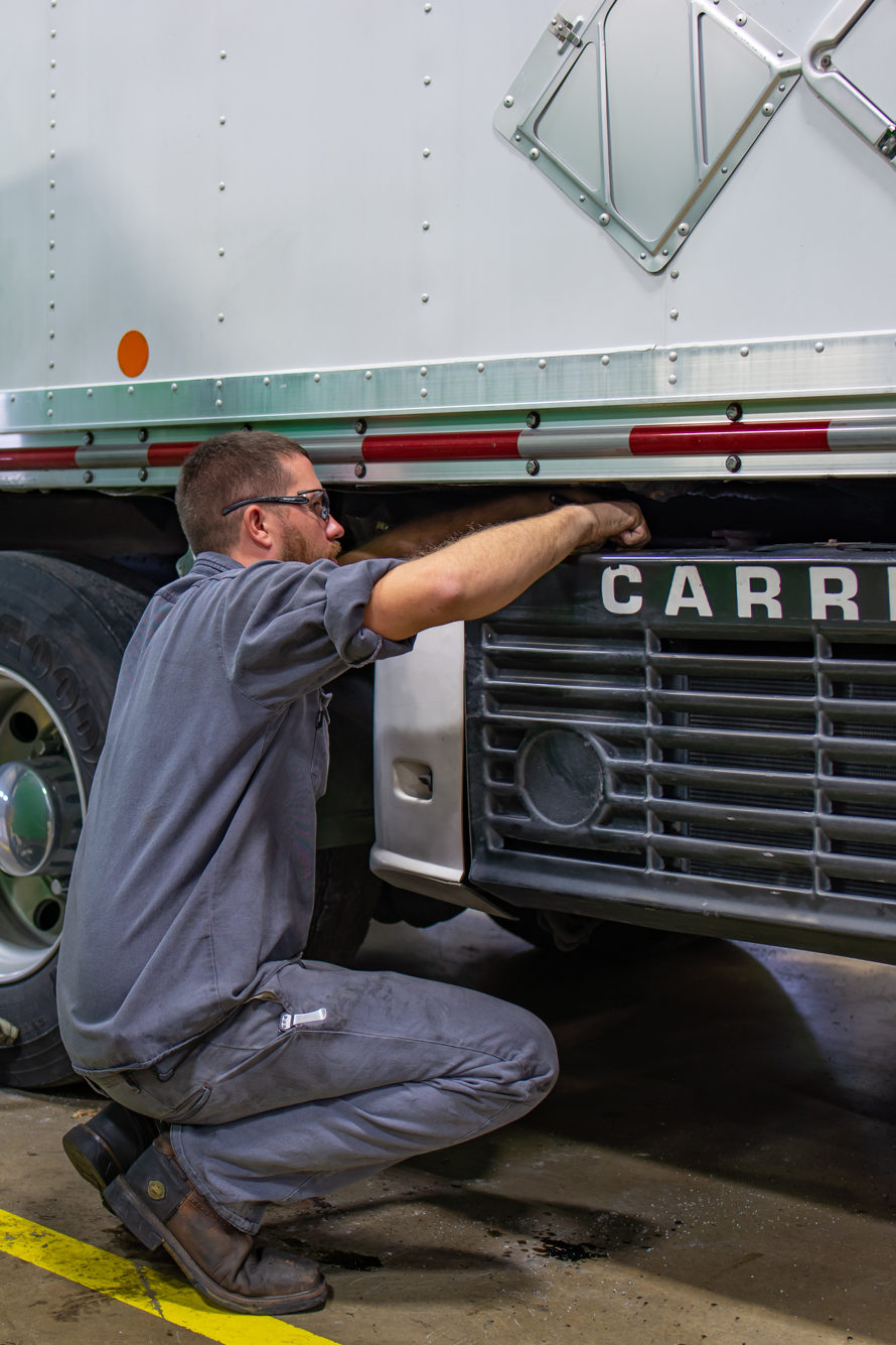 Technician Working on an under mount Carrier Truck Unit